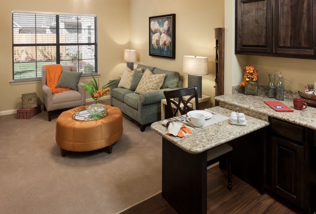 A cozy living room featuring a sofa, coffee table, and kitchen counter with modern decor.