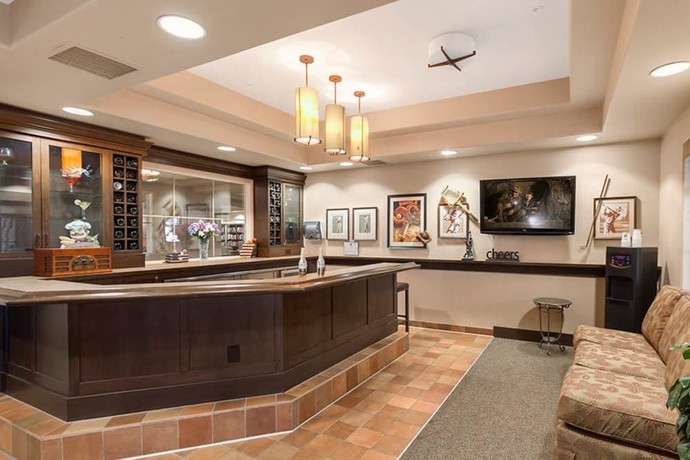 A modern reception area with a wooden counter, artwork, and elegant lighting.