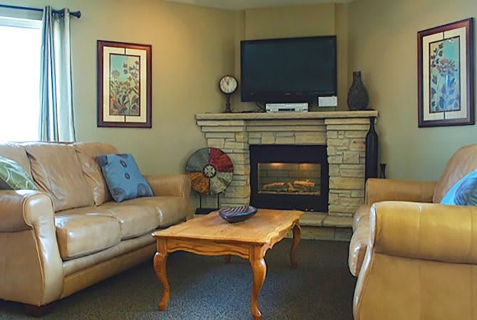 A cozy living room featuring a fireplace, television, and comfortable seating.