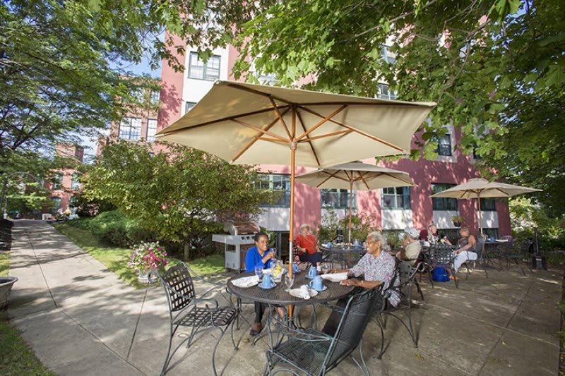 People enjoying a meal under umbrellas at an outdoor cafe.