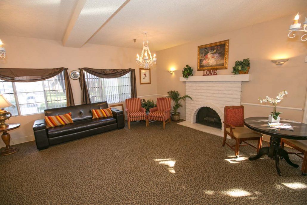 A cozy living room featuring a sofa, two chairs, a fireplace, and elegant decor.