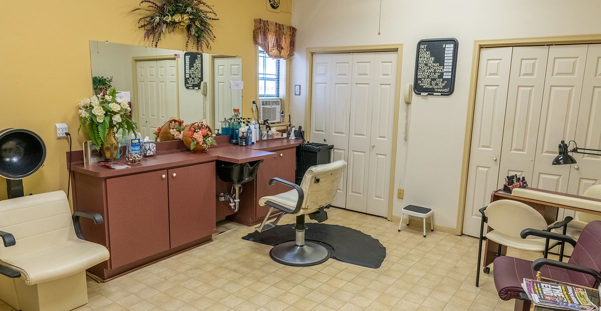 A cozy hair salon with a styling chair, mirrors, and hair products.