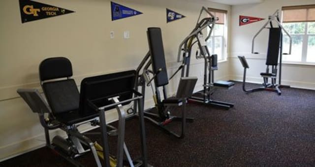 A small gym with various workout machines and exercise equipment.
