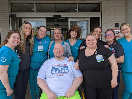 A joyful group of healthcare staff posing together outside, showcasing their camaraderie and dedication.