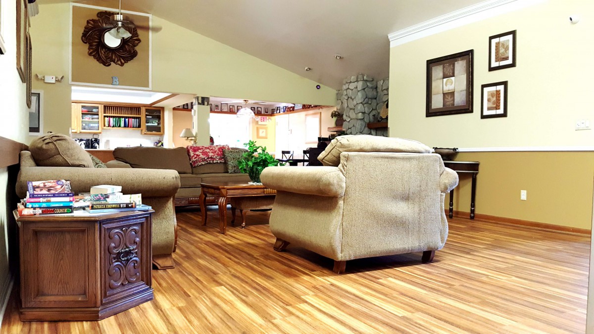A cozy living room with comfortable armchairs and a sofa, featuring wood flooring and stylish decor.