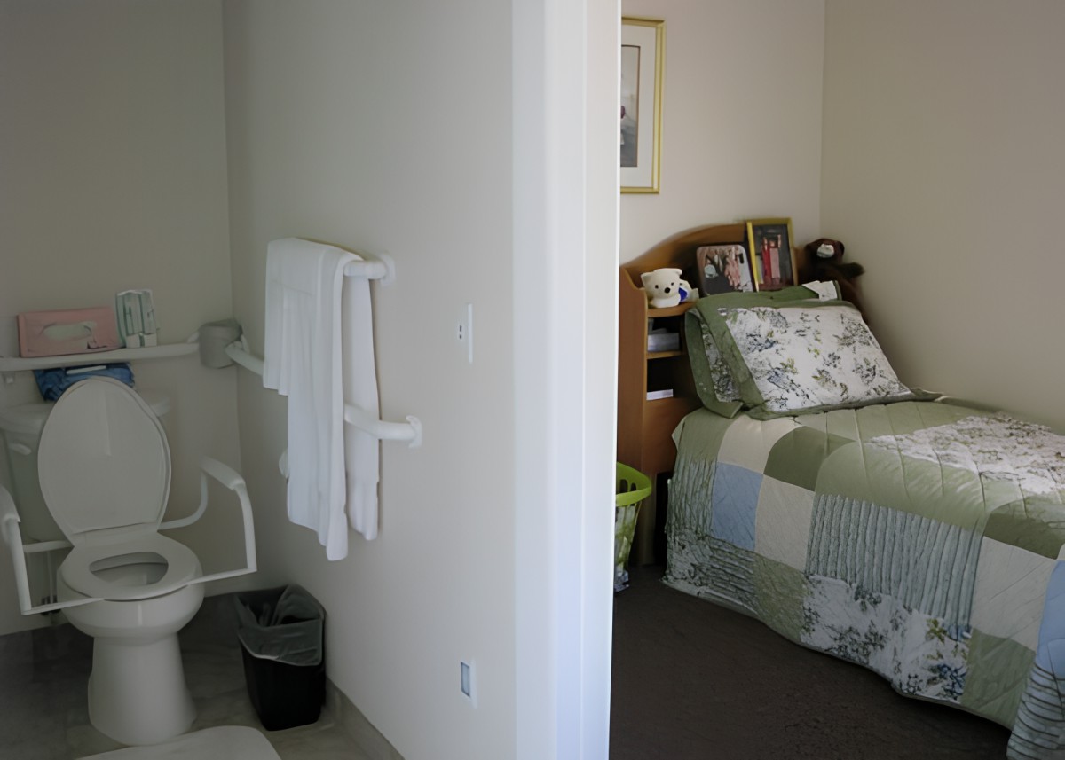 A view of a cozy bedroom with an adjacent bathroom.