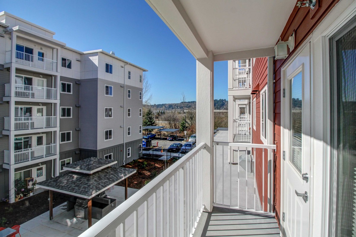 A balcony view of an urban apartment complex on a clear day.