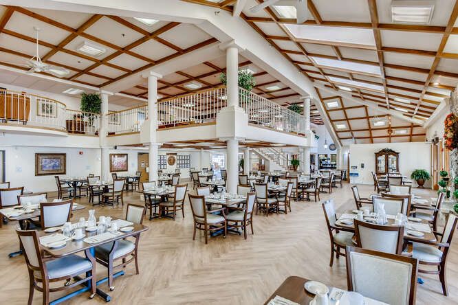 A spacious and elegantly designed restaurant dining area with neatly arranged tables and chairs.