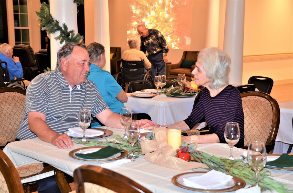 A couple enjoying a conversation at a festively decorated dinner table.