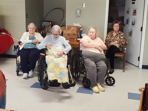 A group of elderly women sitting together in a care facility.