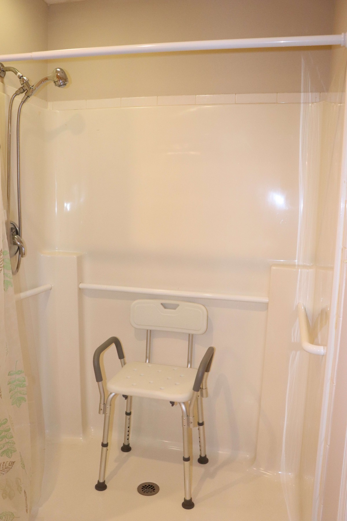 A bathroom shower equipped with a safety chair for accessibility.