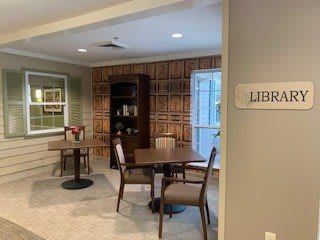 Cozy library corner with tables and chairs for reading.