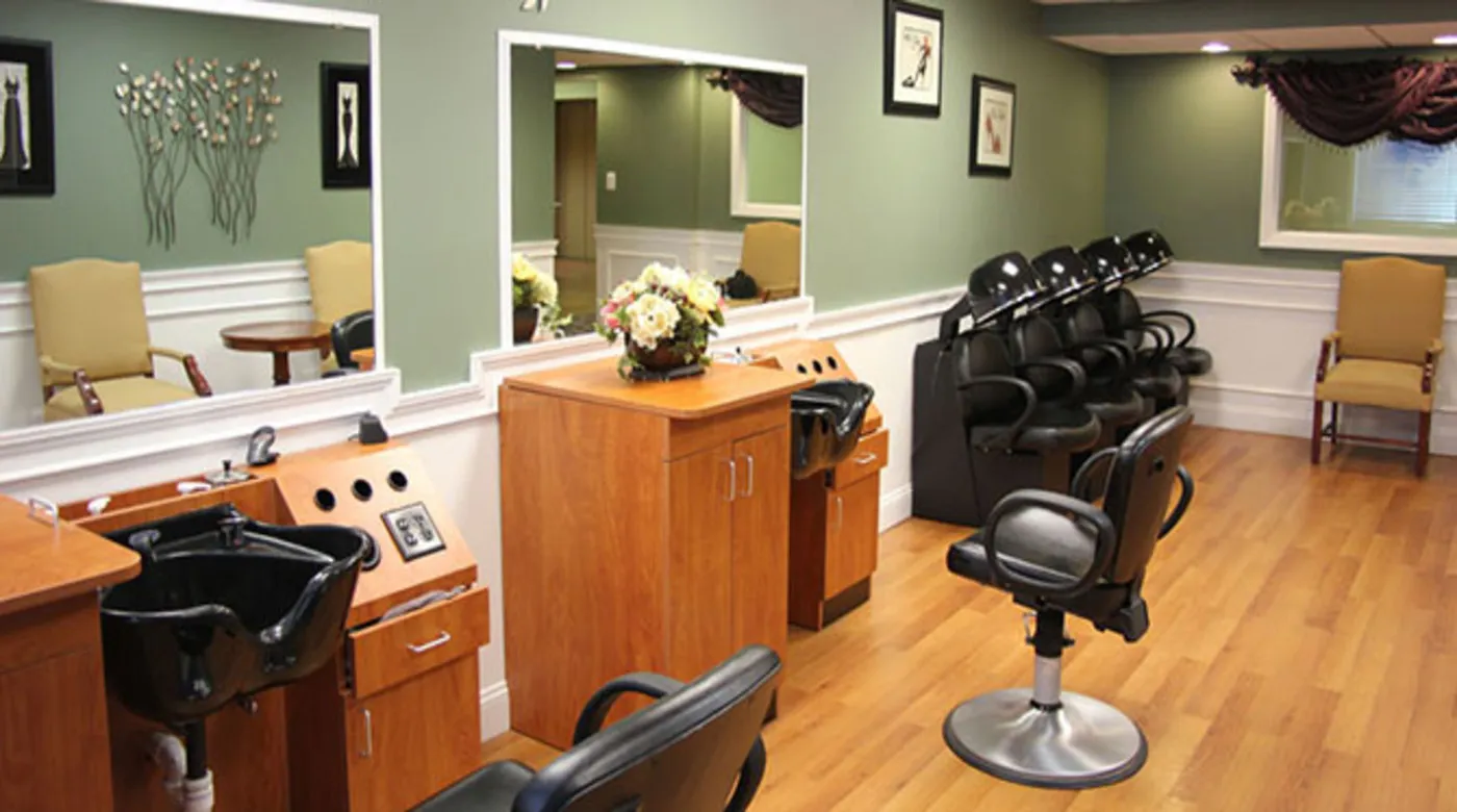 An interior view of a hair salon with chairs and mirrors along one wall.