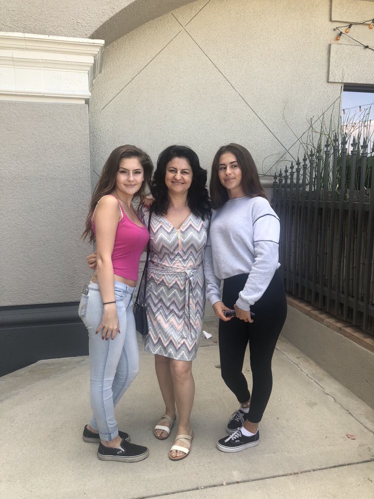 Three women posing for a photo outdoors in casual attire.