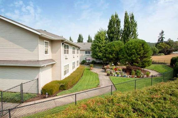 A well-maintained apartment complex with lush landscaping and a garden path.
