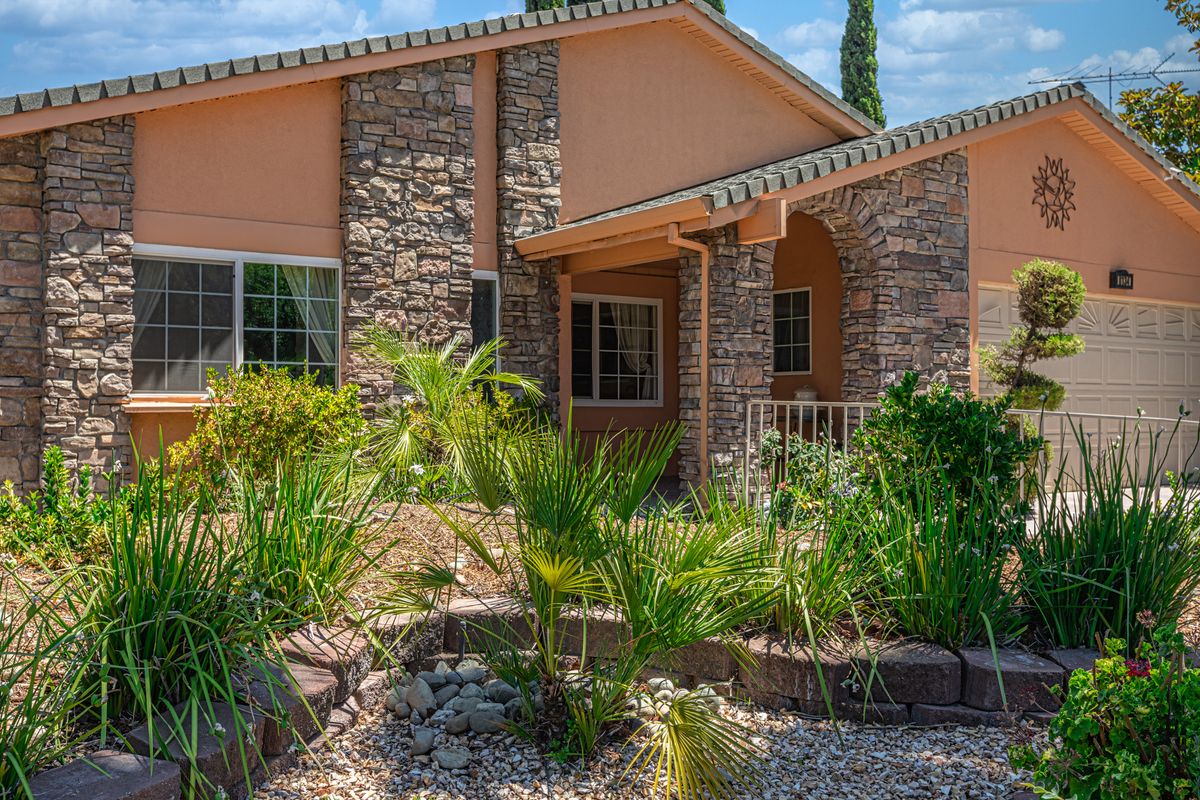 A beautiful house with a stone facade and well-maintained garden.