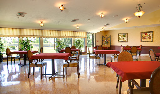 A spacious dining area with red tablecloths and ample natural light.