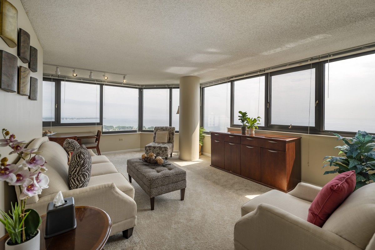 A modern living room with large windows, comfortable seating, and elegant decor.