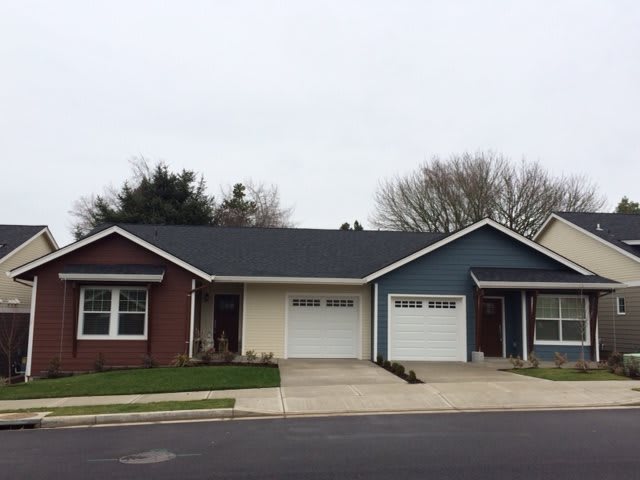 A suburban duplex with attached garages and small lawns.