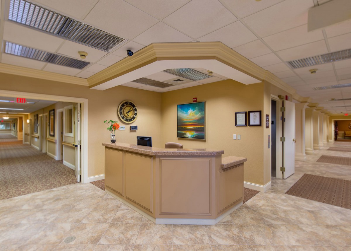 A neatly organized reception area with a desk and artwork on the walls.