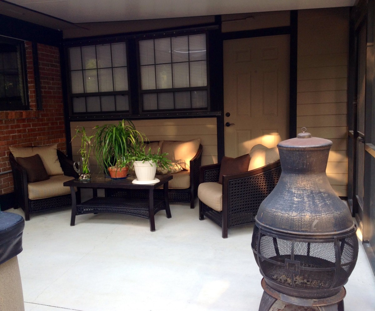 A cozy patio with comfortable seating, a chiminea, and plants creating a welcoming outdoor space.