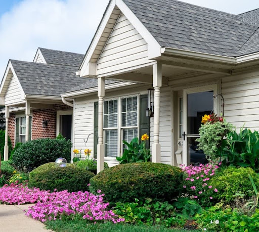 A charming residential house with vibrant flowers in the front yard.
