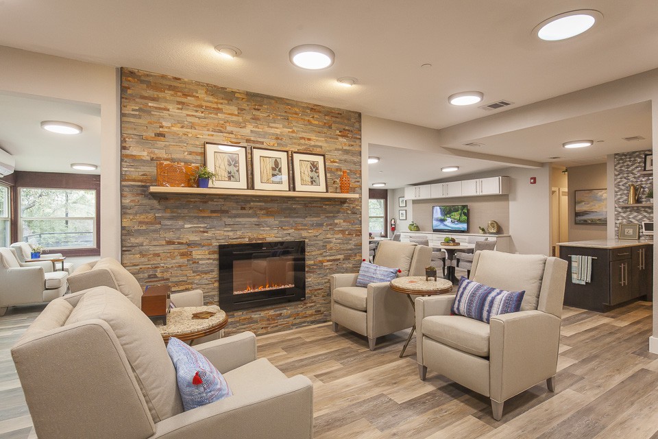 A cozy living room with comfortable armchairs, a stone fireplace, and tasteful decor.