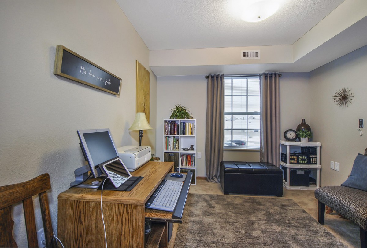 A cozy home office with a desk and computer, neatly organized with a window view.