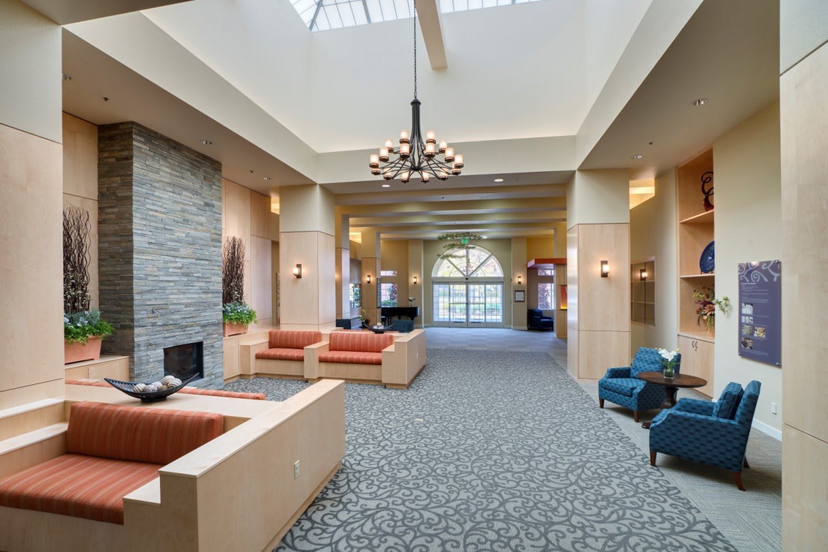 A spacious lobby with comfortable seating and a large chandelier.