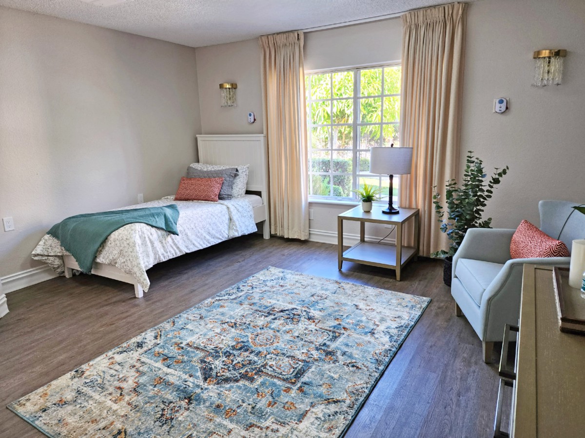 A cozy, modern bedroom with a single bed, stylish furniture, and plenty of natural light.