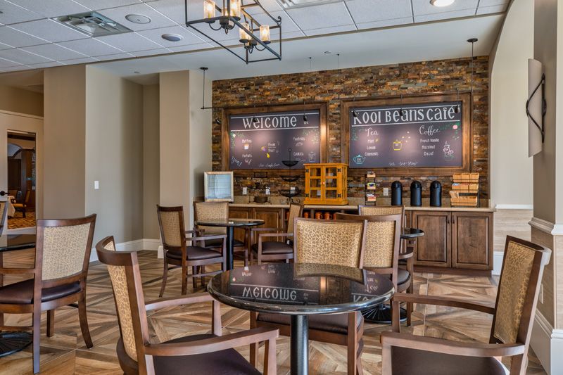 A cozy coffee shop interior featuring wooden decor, tables and chairs, and menu boards.