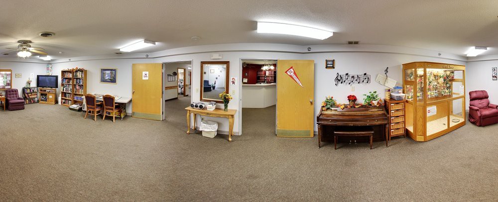 A wide view of an office reception area with doors, a hallway, and various decorations.