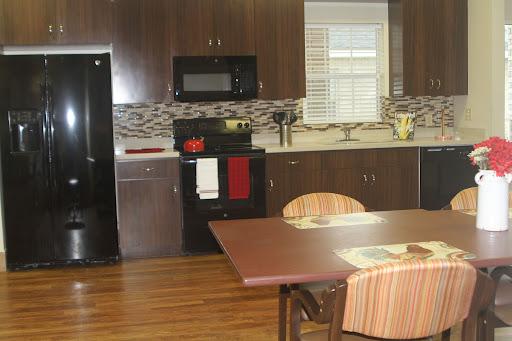 A modern kitchen featuring a dining area with wooden floors and contemporary appliances.