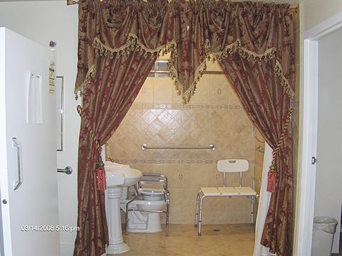 A luxurious bathroom with ornate curtains and a tiled shower area.