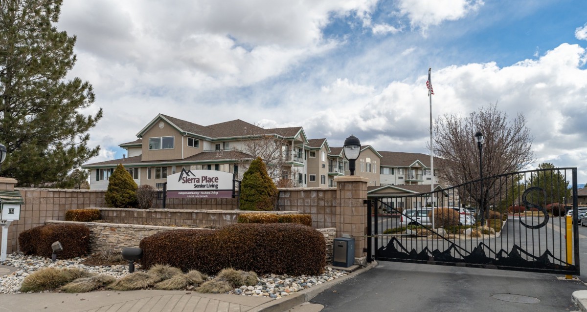 A view of a gated residential apartment complex with a cloudy sky in the background.