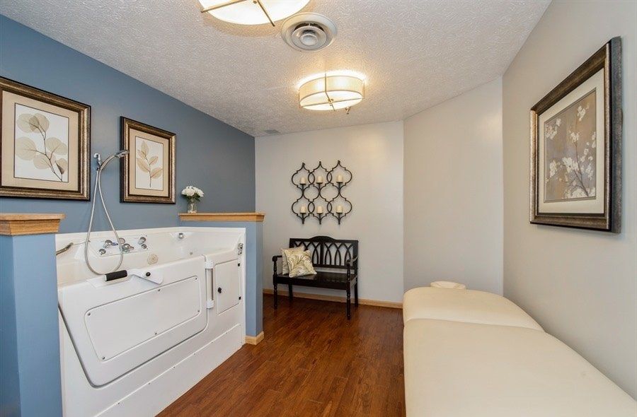 A cozy relaxation room featuring a walk-in tub and seating area with modern decor.