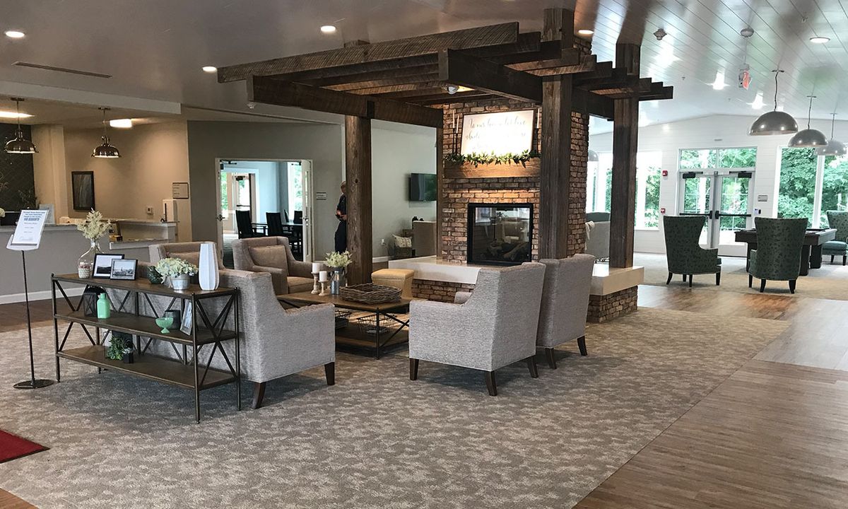 A modern living room with comfortable seating and a central fireplace.
