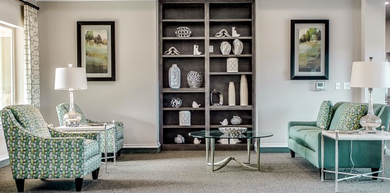 A well-decorated living room featuring shelves with ceramic pieces and modern furniture.