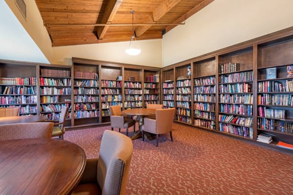 A cozy library reading room with bookshelves and comfortable seating.