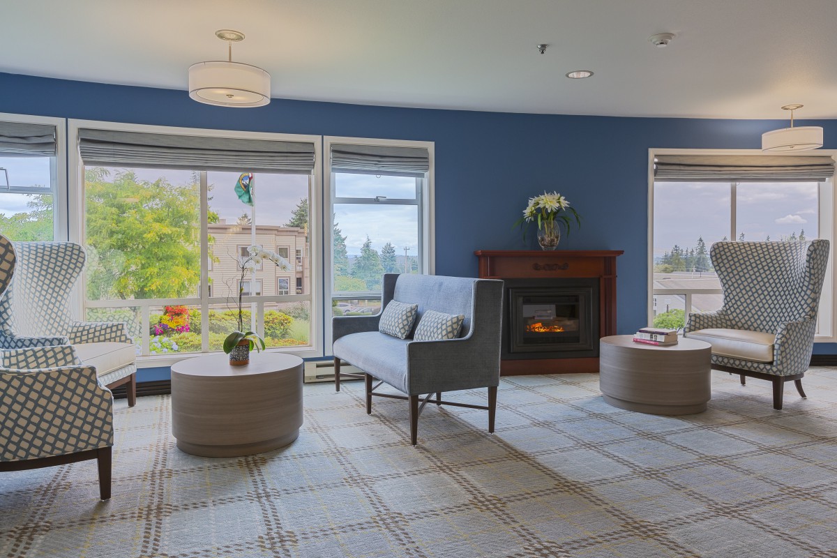 A cozy living room with a fireplace and large windows offering a scenic view.