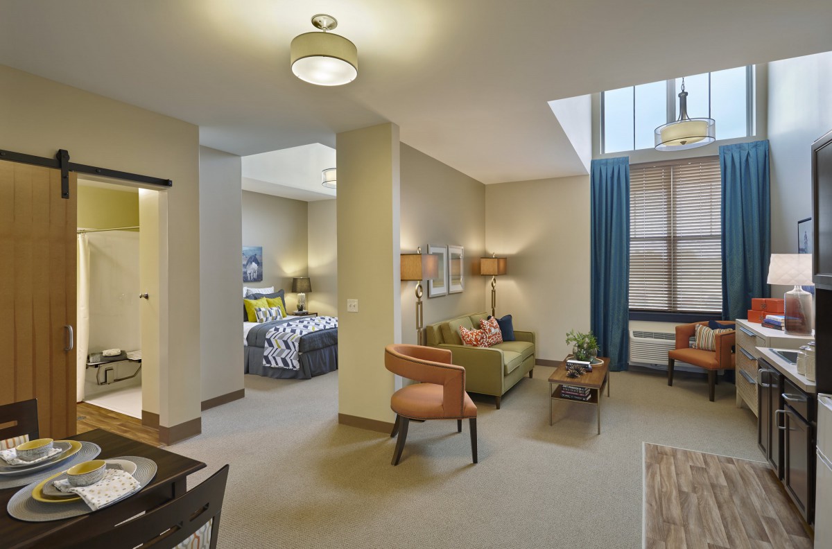 A modern apartment with an open living area featuring stylish furniture and ample natural light.