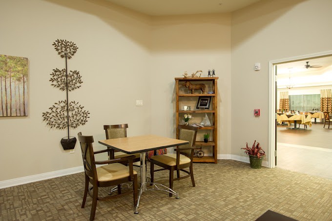 A small, cozy room with a table and chairs, adorned with decor and a bookshelf.