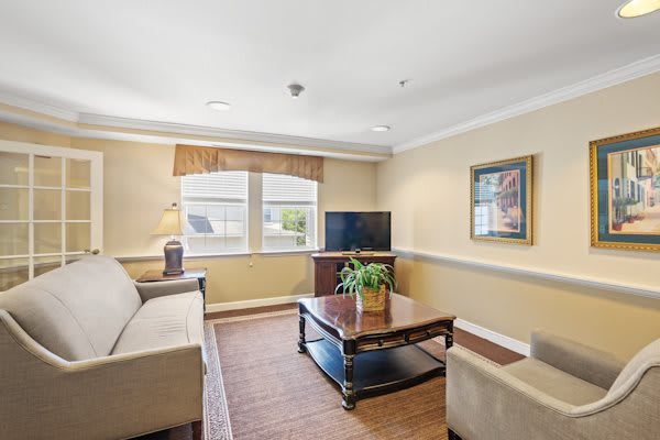 A cozy living room with a sofa, coffee table, and television.
