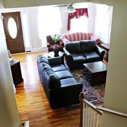 A cozy living room with two sofas, a coffee table, and wooden flooring.