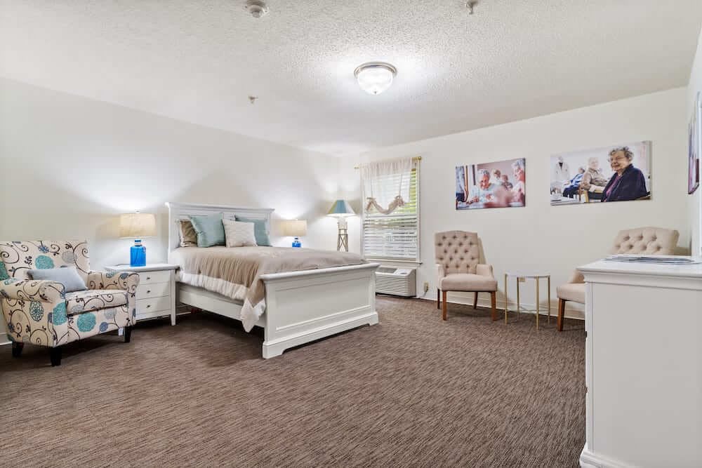 A spacious and elegantly decorated bedroom with a large bed and cozy seating area.