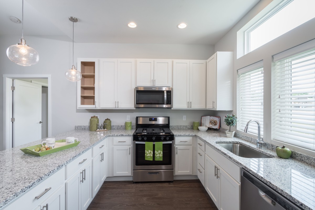 A modern kitchen with white cabinets and stainless steel appliances.
