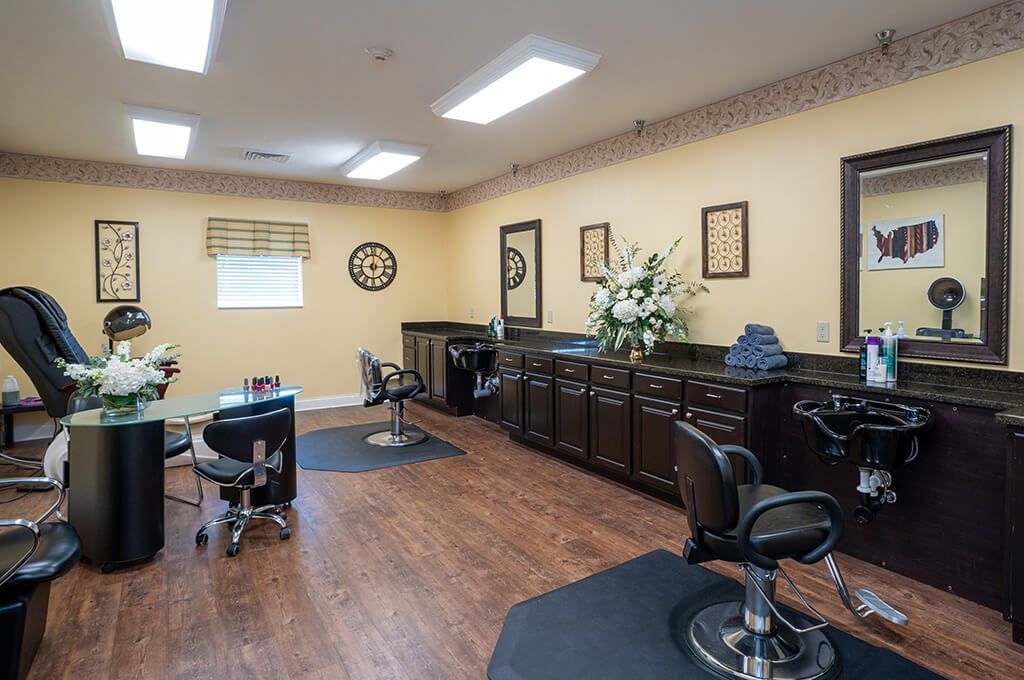 An interior view of a hair salon featuring chairs, mirrors, and wooden flooring.
