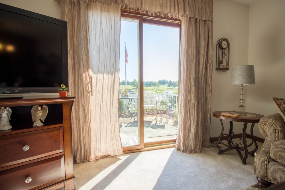 A cozy living room with a sliding glass door letting in abundant sunlight.
