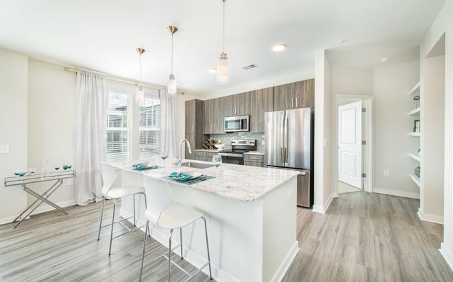 A bright, modern kitchen with a central island and stainless steel appliances.