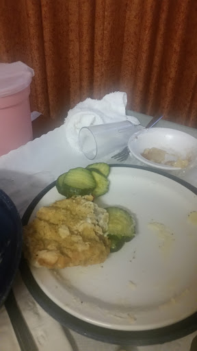 A simple meal featuring some leftovers and cucumber slices on a plate.